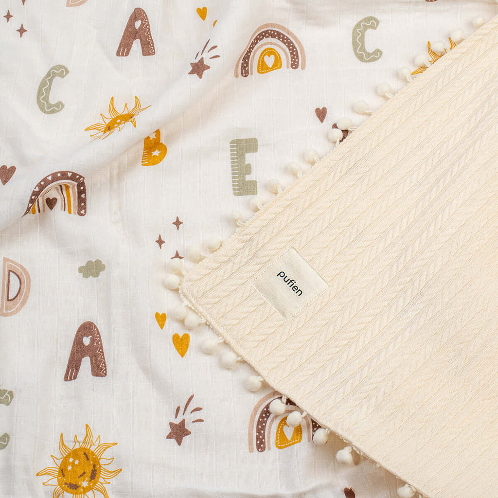 Ponponlu ekru bebek örtüsü, harf desenli pamuk kumaş