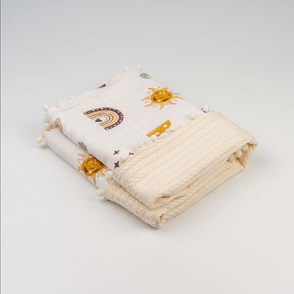 Katlanmış ekru harf desenli ponponlu bebek örgü battaniyesi