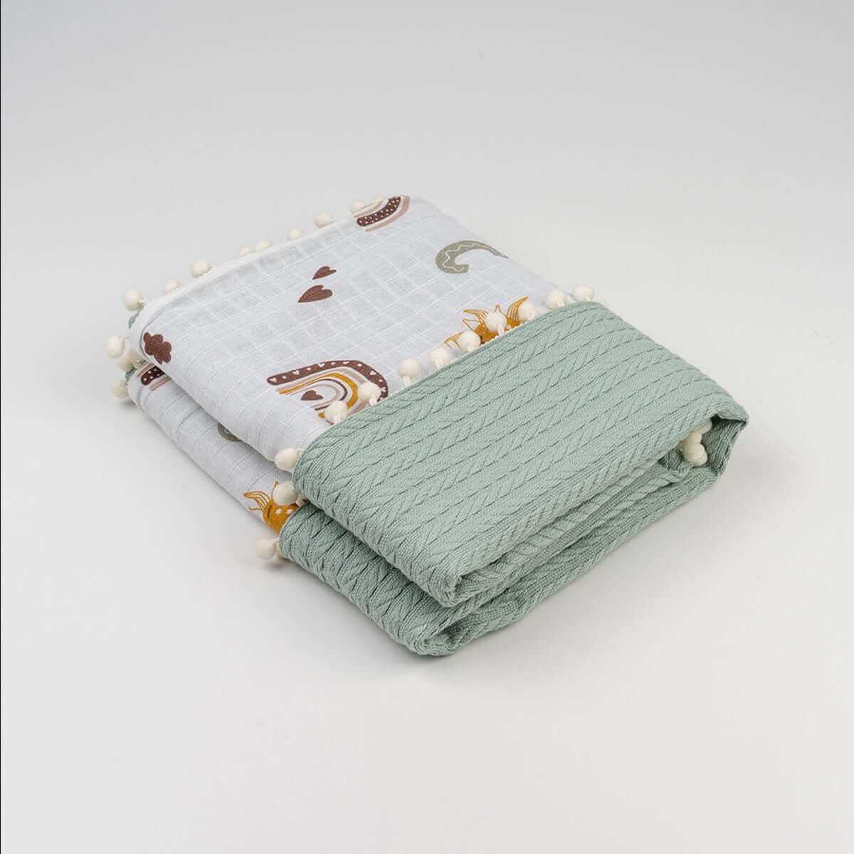 Katlanmış yeşil harf desenli örgü bebek örtü, ponponlu"