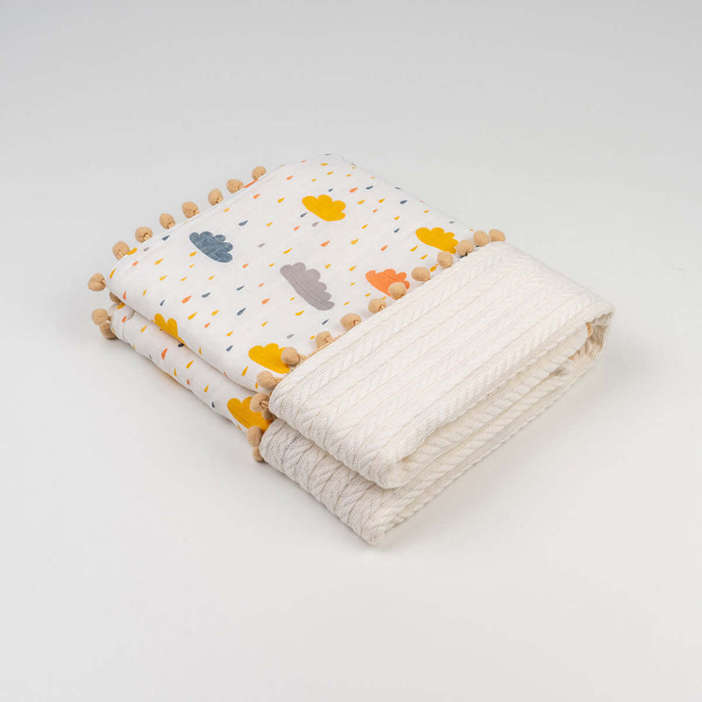 Katlanmış beyaz ponponlu bulut desenli ponponlu örgü örtü